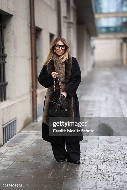 Oeznur Sinani alias Sinperi is seen wearing a long black wool coat from Max Mara; wide-leg black tailored trousers with relaxed fit from COS; black...