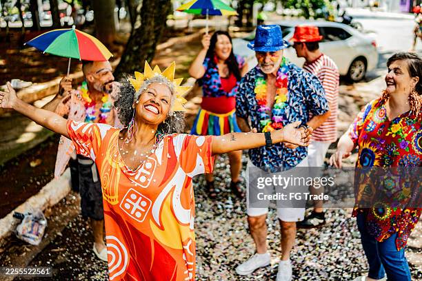 excited senior woman celebrating carnival outdoors - dance music stock pictures, royalty-free photos & images