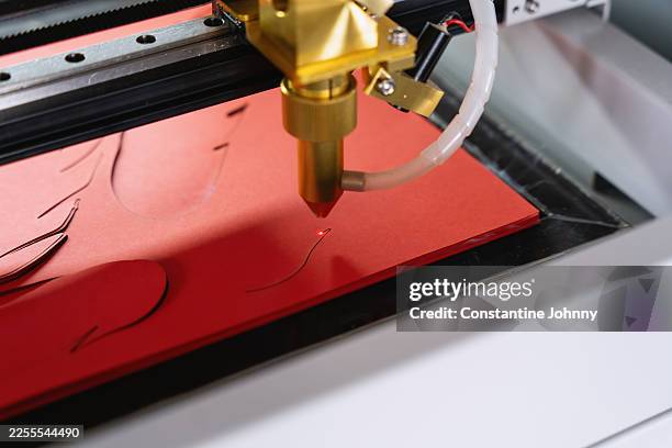 industrial cnc laser cutter precision cutting red paperboard - laser engraving stock pictures, royalty-free photos & images