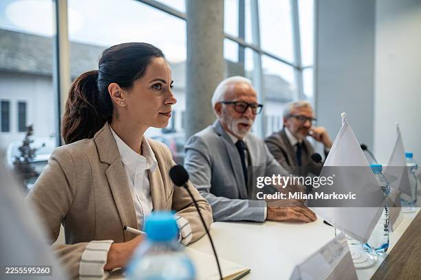 podiumsteilnehmer diskutieren wichtige themen auf einer politischen konferenz - botschafter stock-fotos und bilder