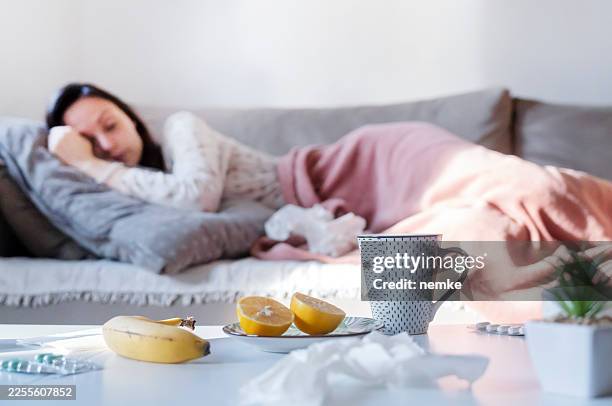 female shiver at freezing flat in warm cap blanket - immune system stock pictures, royalty-free photos & images