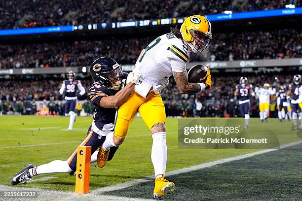 Christian Watson of the Green Bay Packers scores a touchdown against Nick McCloud of the Chicago Bears during the first quarter in the NFC Wild Card...