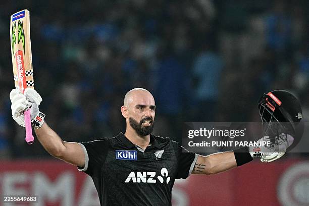 New Zealand's Daryl Mitchell celebrates after scoring a century during the second one-day international cricket match between India and New Zealand...