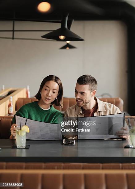 joyful married couple enjoying a warm dining experience at a modern restaurant - menu stock pictures, royalty-free photos & images