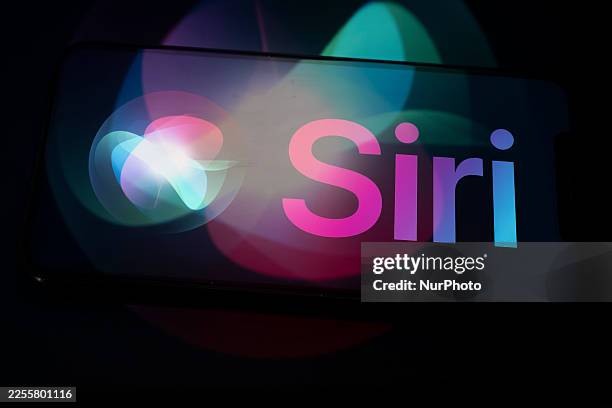 The Siri logo appears on the screen of a smartphone placed on a surface reflecting the new Siri logo. Google and Apple enter into a collaboration...