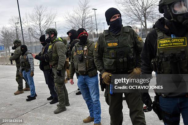 Federal law enforcement agents confront anti-ICE protesters during a demonstration outside the Bishop Whipple Federal Building in Minneapolis,...
