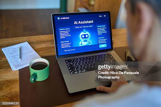 over the shoulder view of man using ai assistant on laptop at desk. - computer screen over shoulder office stock pictures, royalty-free photos & images