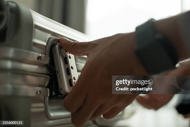 close-up of hand locking suitcase latch. - window latch stock pictures, royalty-free photos & images