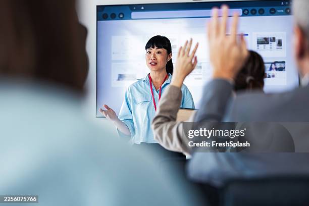 confident woman leads professional presentation to engaged audience in office conference room - slide show stock pictures, royalty-free photos & images