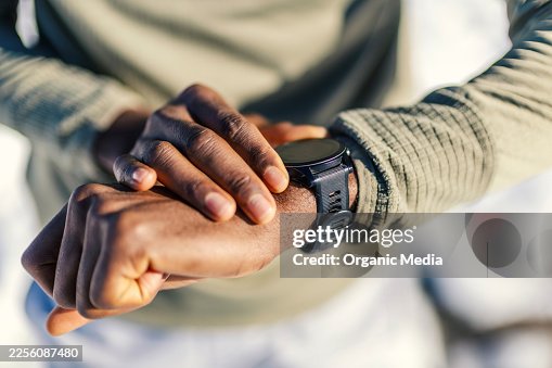Man checking smart watch while exercising outdoors Man checking smart watch while exercising outdoors