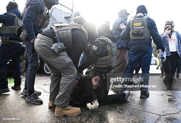 Agents detain a woman after pulling her from a car before on January 13, 2026 in Minneapolis, Minnesota. The Trump administration has deployed over...