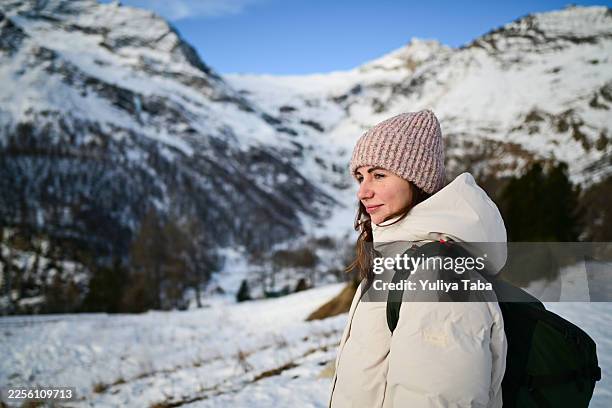 woman hiking in snowy mountains during winter - white jacket stock pictures, royalty-free photos & images