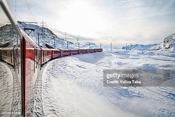 bernina express train traveling through snowy swiss alps panorama - glacier express stock pictures, royalty-free photos & images