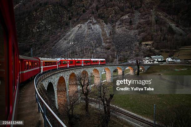 bernina-express-rotbahnüberquerung des spiralviadukts brusio - schienenverkehr stock-fotos und bilder