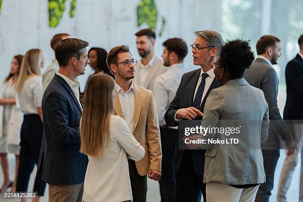 empresarios haciendo networking y debatiendo durante el evento de la conferencia - aventura fotografías e imágenes de stock