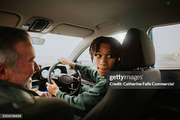 a young man carefully reverses a car, encouraged by his driving instructor during a lesson - reversing stock pictures, royalty-free photos & images