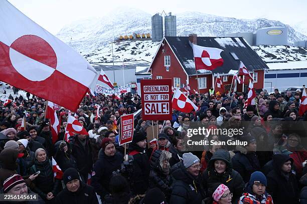 People hold Greenlandic flags and placards as they gather by the United States Consulate to march in protest against U.S. President Donald Trump and...