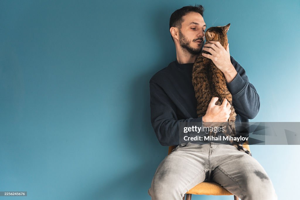 家にいる男性と猫とのペットペアレンティングコンセプトとコピースペース