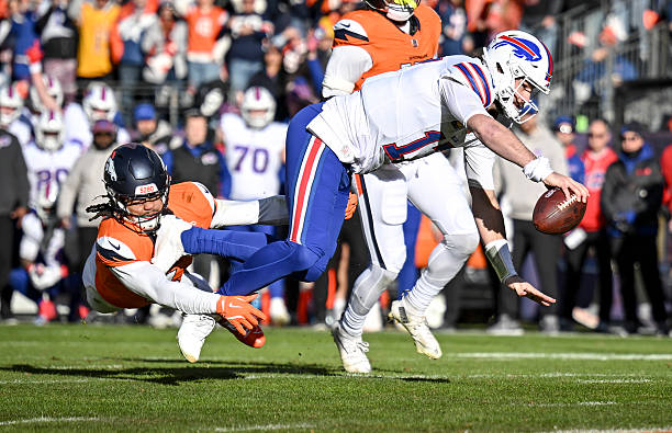 Locke of the Denver Broncos makes a touchdown-saving tackle as Josh Allen of the Buffalo Bills stretches during the first quarter at Empower Field at...