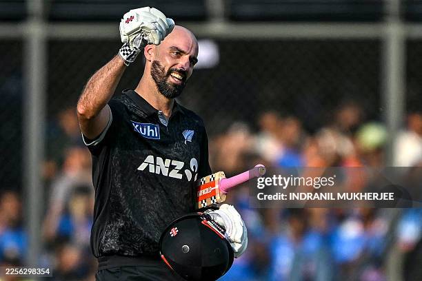 New Zealand's Daryl Mitchell celebrates after scoring a century during the third one-day international cricket match between India and New Zealand at...