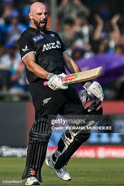 New Zealand's Daryl Mitchell celebrates after scoring a century during the third one-day international cricket match between India and New Zealand at...