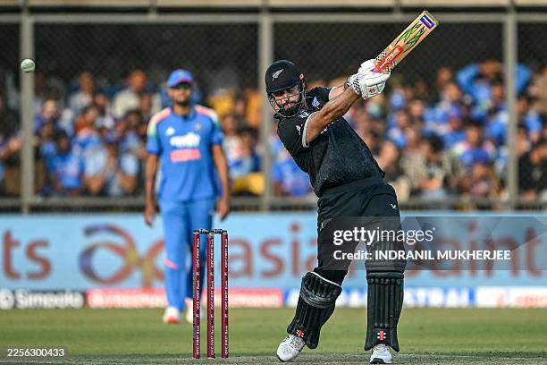 New Zealand's Daryl Mitchell plays a shot during the third one-day international cricket match between India and New Zealand at the Holkar Cricket...