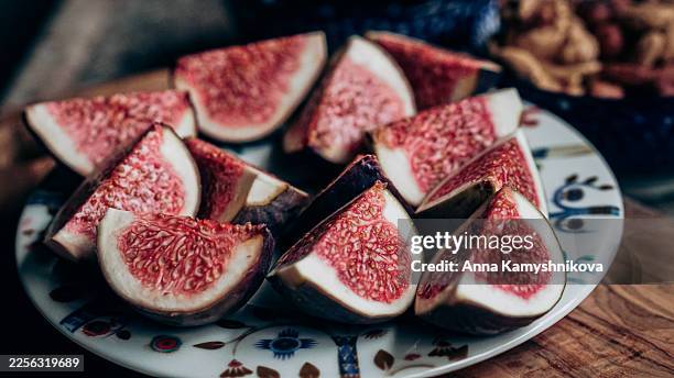 quartered figs on patterned saucer - vibrant whole food with nutrient-rich texture - mediterranean food stock pictures, royalty-free photos & images