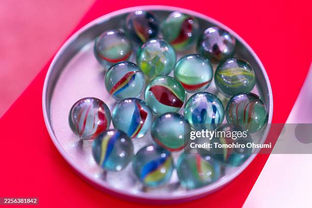 Marbles are seen on a table in the Marbles room during a media preview of the Squid Game: The Experience - Shibuya event on January 15, 2026 in...