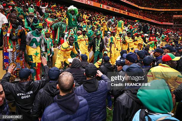 Security personnel block angry fans over a penalty decision against Senegal during the Africa Cup of Nations final football match between Senegal and...