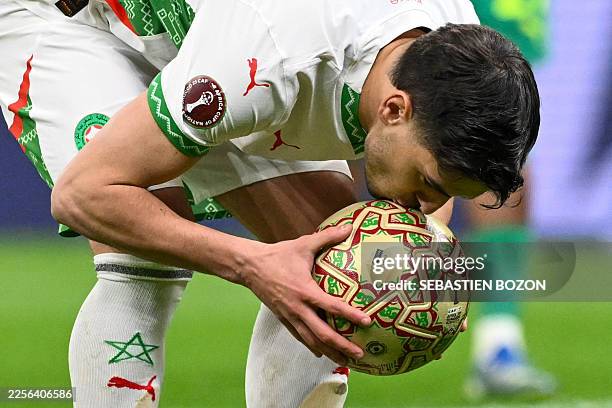 Morocco's forward Brahim Diaz kisses the ball before a penalty kick during the Africa Cup of Nations final football match between Senegal and Morocco...