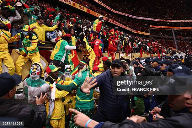 Fans scuffle with security personnel as they storm the field after a penalty decision against Senegal during the Africa Cup of Nations final football...