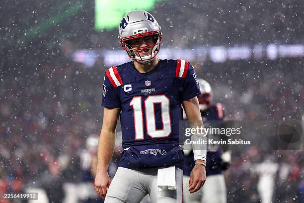 Drake Maye of the New England Patriots celebrates after throwing a touchdown pass during the fourth quarter of an NFL divisional playoff football...