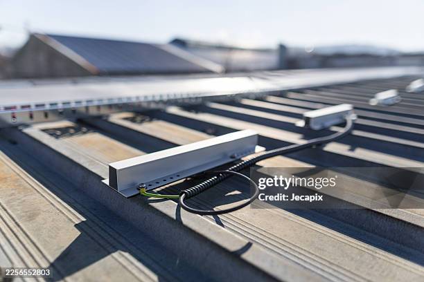 herraje eléctrico para tejados metálicos con raíles, cables y estructura iluminada por el sol - hoja de aluminio fotografías e imágenes de stock