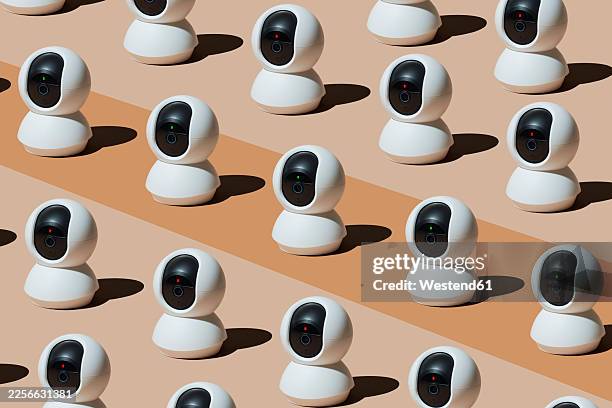 multiple surveillance cameras arranged in playful pattern indoors - camera sensor stock illustrations