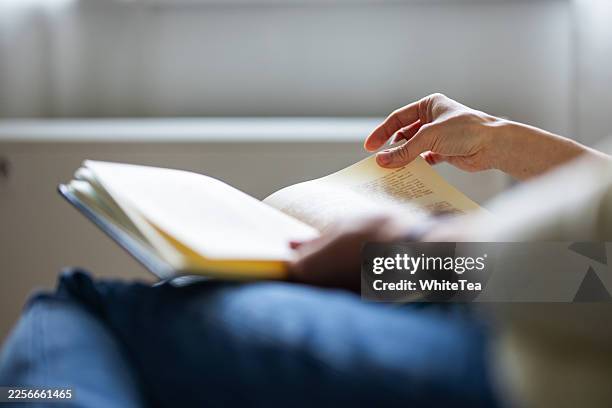 persona che legge un libro aperto in una stanza silenziosa - open book foto e immagini stock