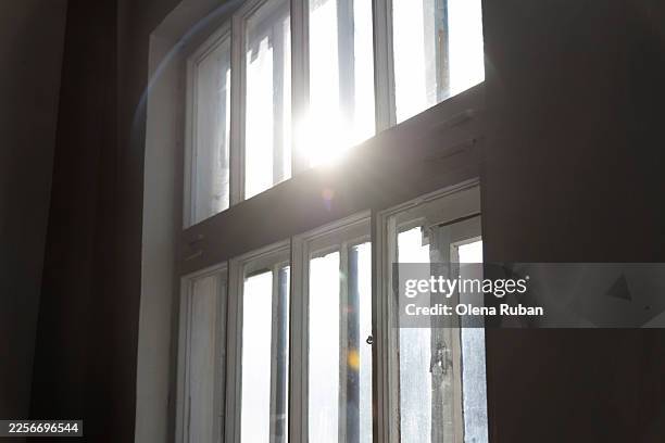 bright sunlight streams through the panes of a large window. - window latch stock pictures, royalty-free photos & images