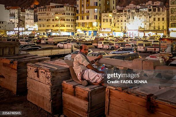 Man sits on wooden crates on the promenade in Al-Mukalla, in Yemen's southern coastal Hadramawt province, on January 20, 2026.
