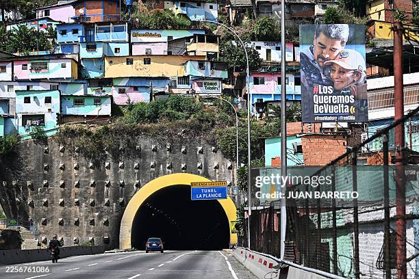 Billboard depicting ousted Venezuela's President Nicolas Maduro and his wife Cilia Flores that reads in Spanish "We want them back, FreeMaduro,...
