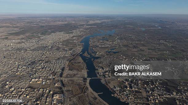An aerial photograph shows a section of the Euphrates River and parts of the Syrian northeastern city of Raqa, once the Islamic State group's de...