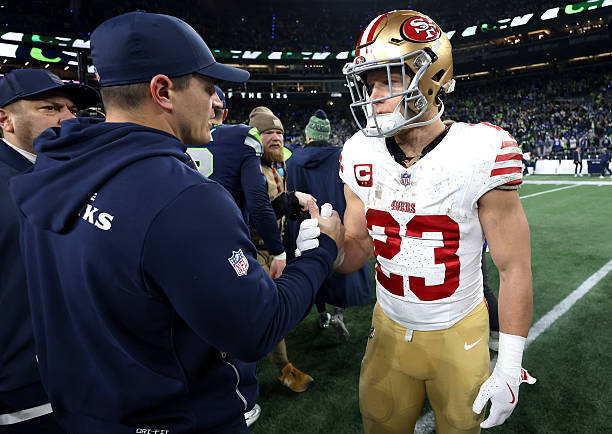 Head coach Mike MacDonald of the Seattle Seahawks shakes hands with Christian McCaffrey of the San Francisco 49ers after the NFC Divisional Playoff...