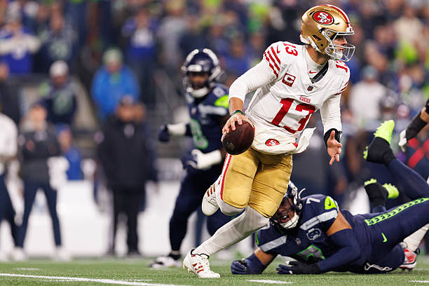 Brock Purdy of the San Francisco 49ers scrambles during the first quarter of an NFL divisional playoff football game against the Seattle Seahawks at...