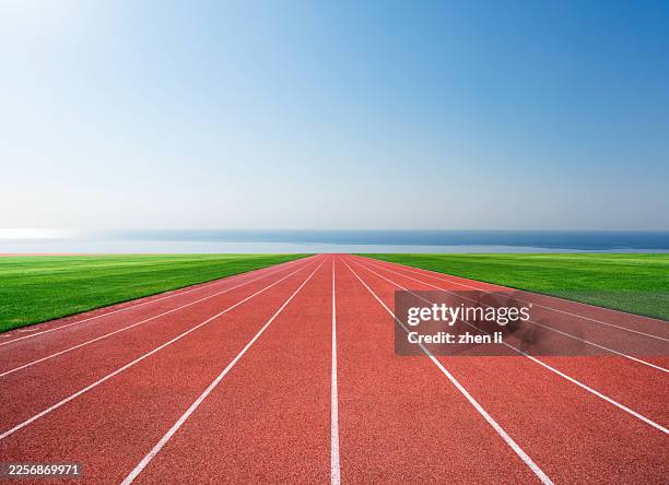 athletics track by the sea - atletiekbaan stockfoto's en -beelden