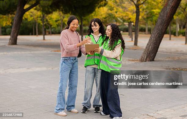 young women volunteers collecting signatures in park - petition stock pictures, royalty-free photos & images