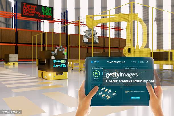 smart warehouse automation worker controlling agv robot using tablet with ar dashboard interface in futuristic logistics center. - agv stock pictures, royalty-free photos & images