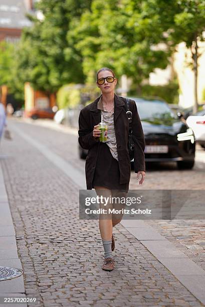 Guest is wearing a dark brown suede jacket with notch lapels and button front closure; a beige and light brown striped short sleeve polo style top...