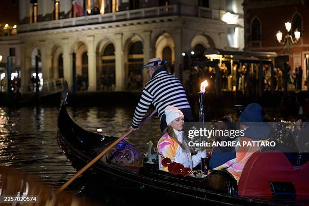 Torchbearer carries the Olympic flame on a gondola in Venice during the Torch Relay to Milano Cortina 2026 Olympic Games, on January 22, 2026.