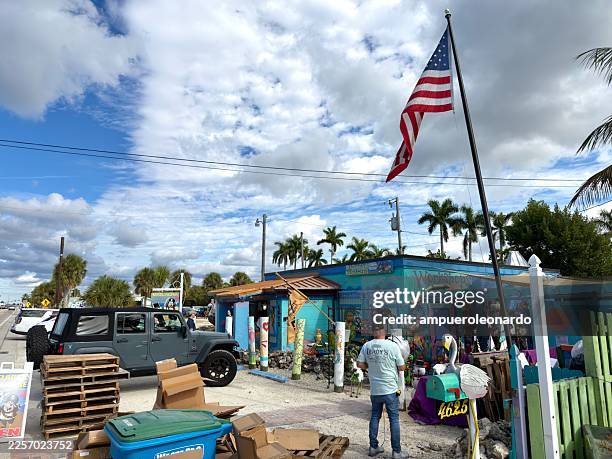 american flag flying over matlacha workshops in florida - matlacha stock pictures, royalty-free photos & images
