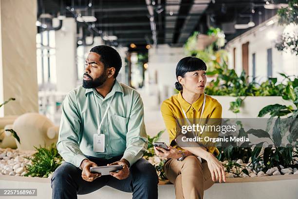 colleagues experiencing workplace tension and communication breakdown - irritatie stockfoto's en -beelden