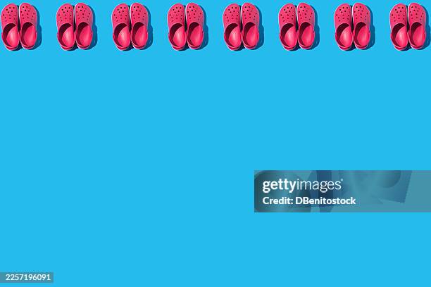 pattern of red foam clogs, on top, on a blue background. concept of summer, footwear, sole, comfort, slippers, rest, ergonomic, plantar fasciitis, feet and rubber. - plantar fasciitis stock pictures, royalty-free photos & images