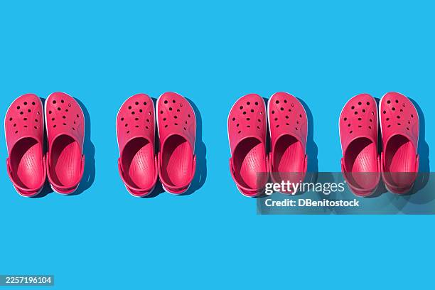pattern of red foam clogs, in a row, on a blue background. concept of summer, footwear, sole, comfort, slippers, rest, ergonomic, plantar fasciitis, feet and rubber. - plantar fasciitis stock pictures, royalty-free photos & images